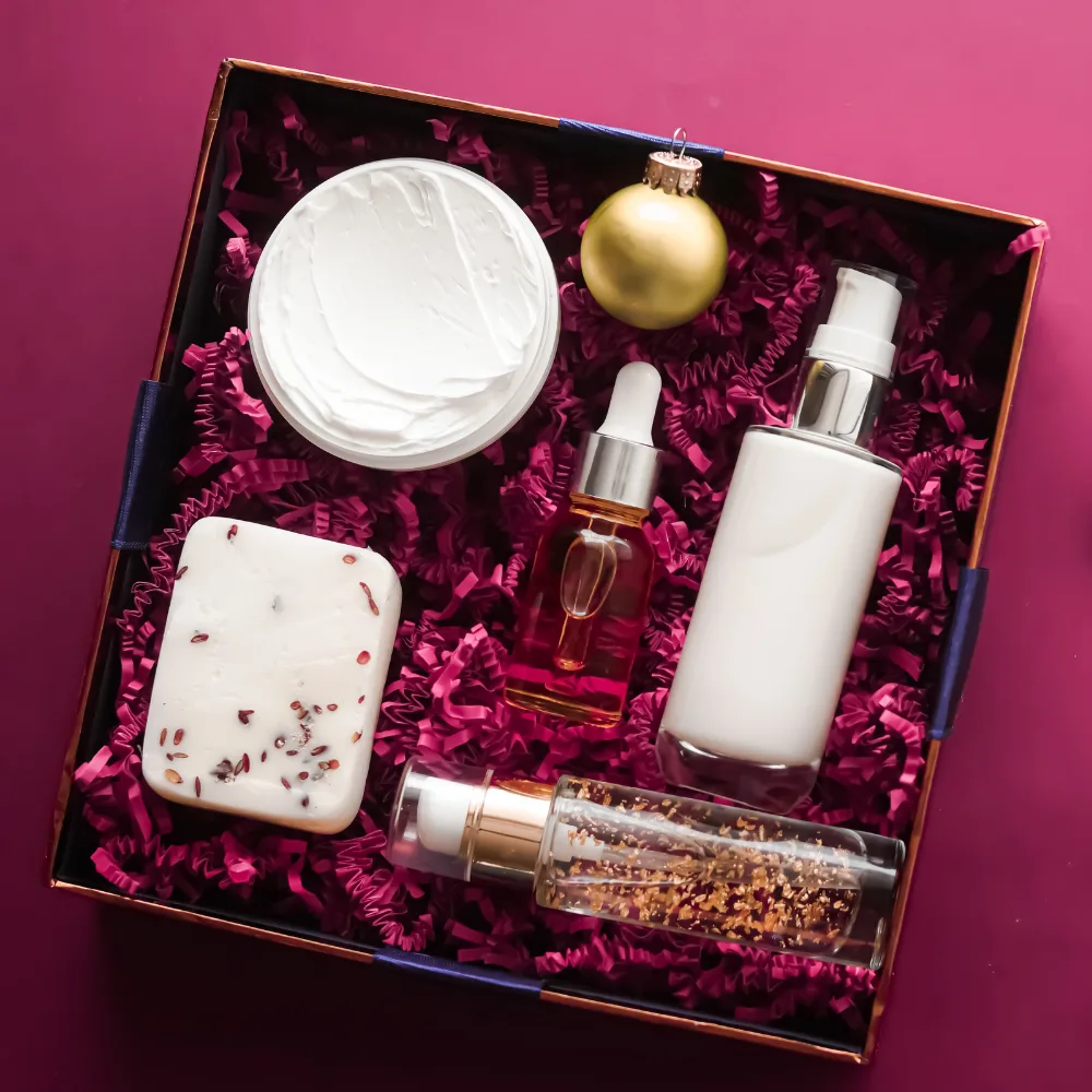 Gift subscription box of skincare and bath products on a pink background