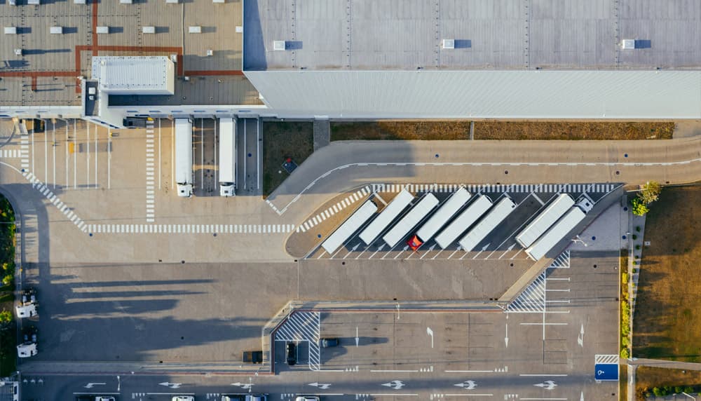 Aerial view of carrier trucks lined up at warehouse loading docks