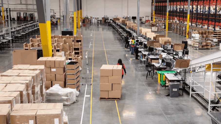 Unified Commerce warehouse floor with pallets of boxes and packing stations