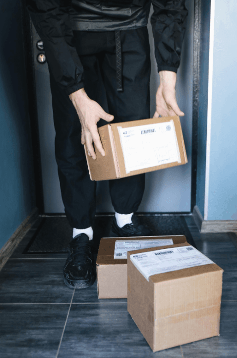 Customer holding a delivered parcel at their front door